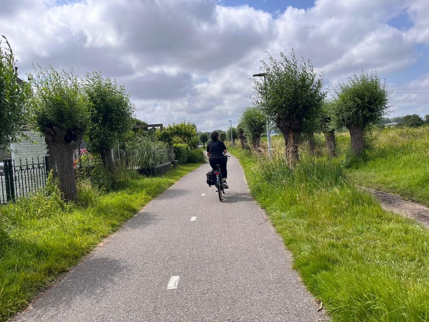 Amsterdam: Rainbow Rural Bike Tour With Local Gay Guide - The ferry ride back: skyline views and a welcome breather