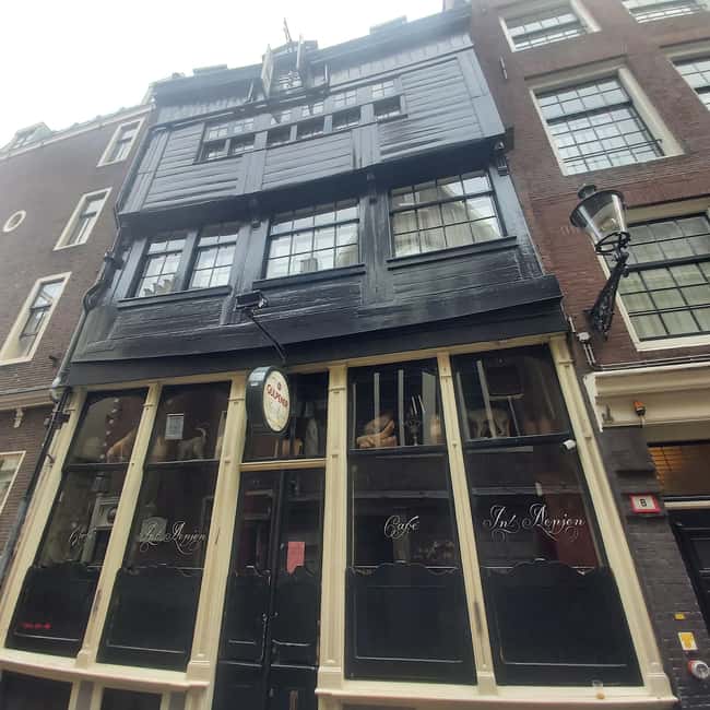 Amsterdam: Spanish Tour Unmasking the Redlight District - Oude Kerk and the canal network that made everything feel close