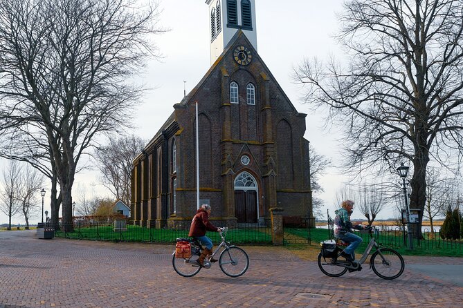 Cheese, Canals & Windmill Countryside E-Bike Tour Amsterdam - Nieuwendammerdijk: green wooden houses and captains’ history
